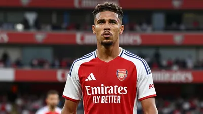 A tight, waist-up shot of a ruggedly-built, late-twenties Brazilian winger with a determined expression, dressed in...