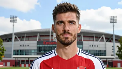 A 30-year-old male Arsenal coach with a strong jawline and a confident expression, wearing a white and red jersey with a...