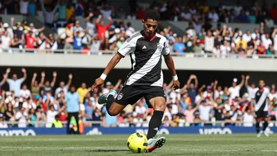 A young Brazilian player in action, wearing a sleek black and white jersey with a red trim, and a bright yellow ball at...
