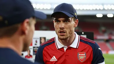 A close-up, waist-up shot of a 28-year-old, ruggedly-built, Belgian full-back in the midst of a heated discussion, his...