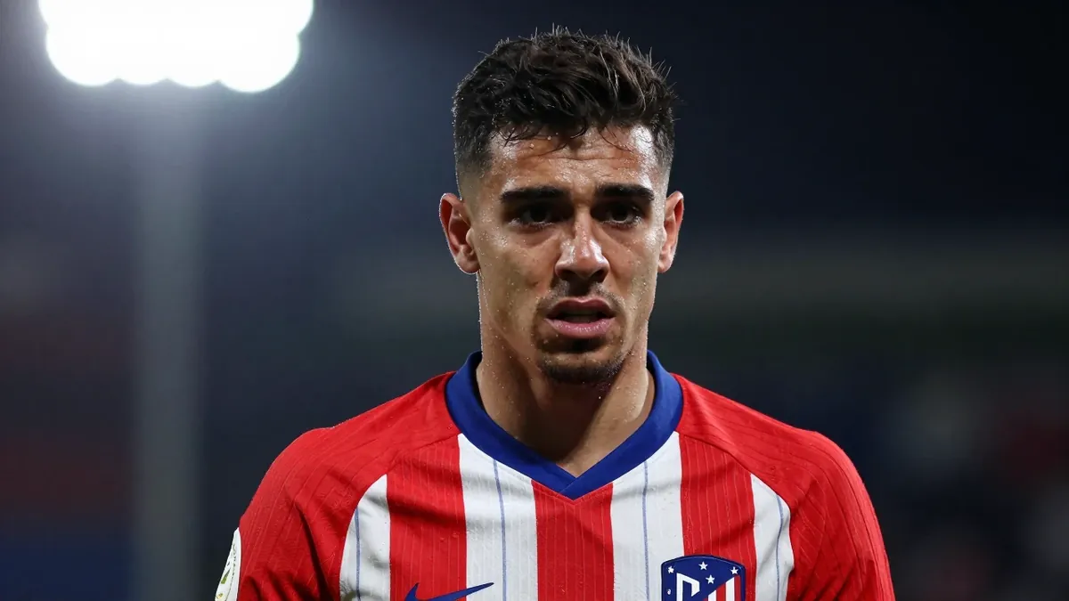 A 25-year-old, athletic, dark-haired Atletico Madrid forward, wearing a red and white kit, looking frustrated, with a...
