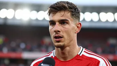 Photorealistic close-up of a 25-year-old Arsenal defender, athletic build, wearing a clean red jersey with smooth fabric...