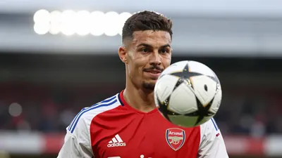 A 25-year-old midfielder, with a strong build and a determined expression, stands in the middle of the pitch, wearing a...