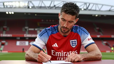A medium shot of a focused, middle-aged England national team defender, around 5'11" with a rugged build, intently...