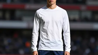 A photorealistic image of a 19-year-old, anonymous, Arsenal academy graduate, wearing a clean, white, long-sleeved...